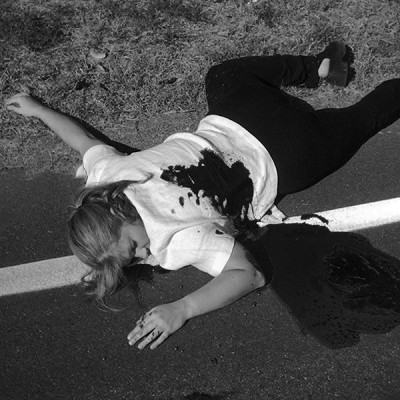 Woman in a blood pool lying on the roadside